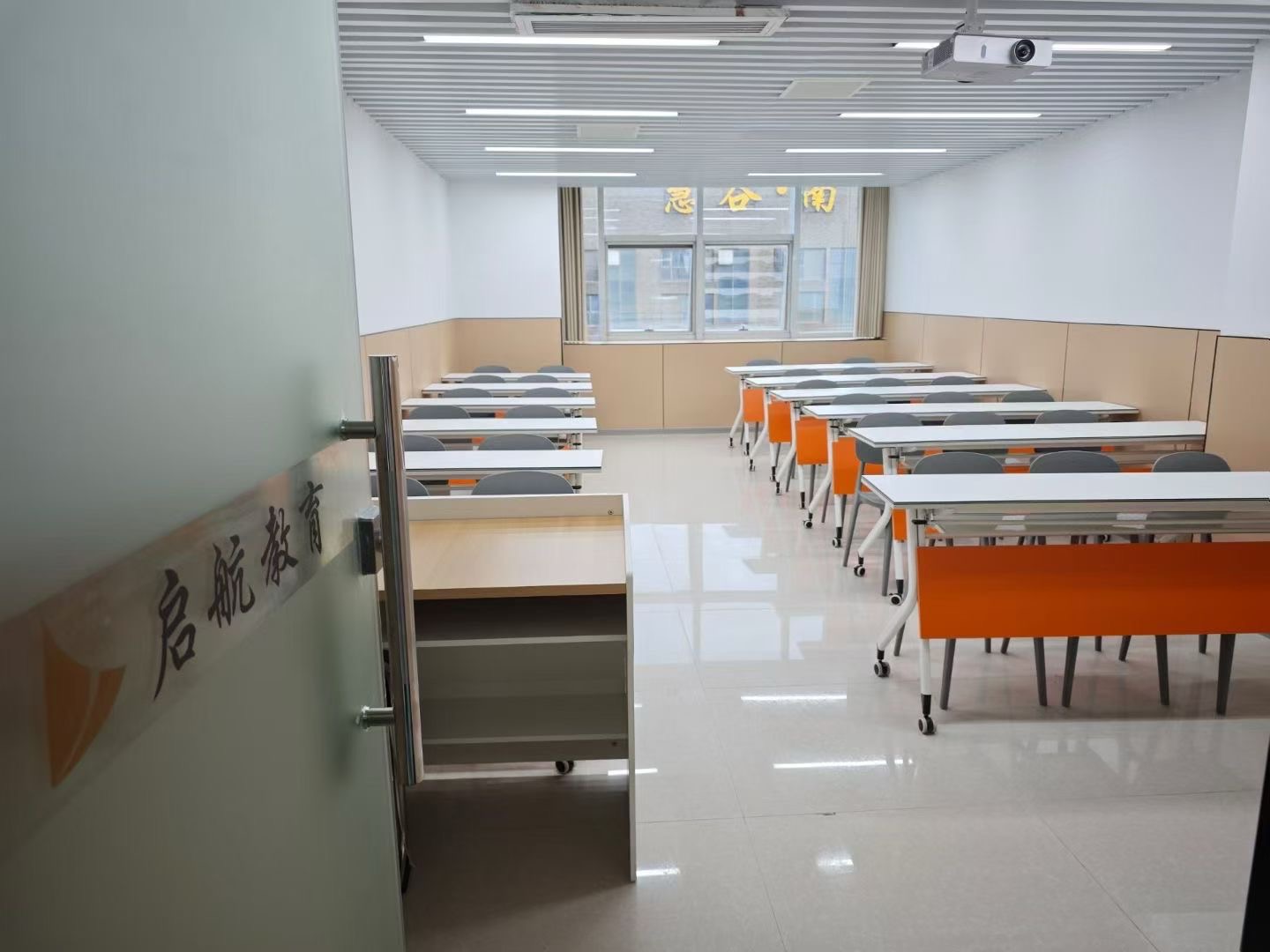 导师与学生在一对一交流，面前有电脑和资料